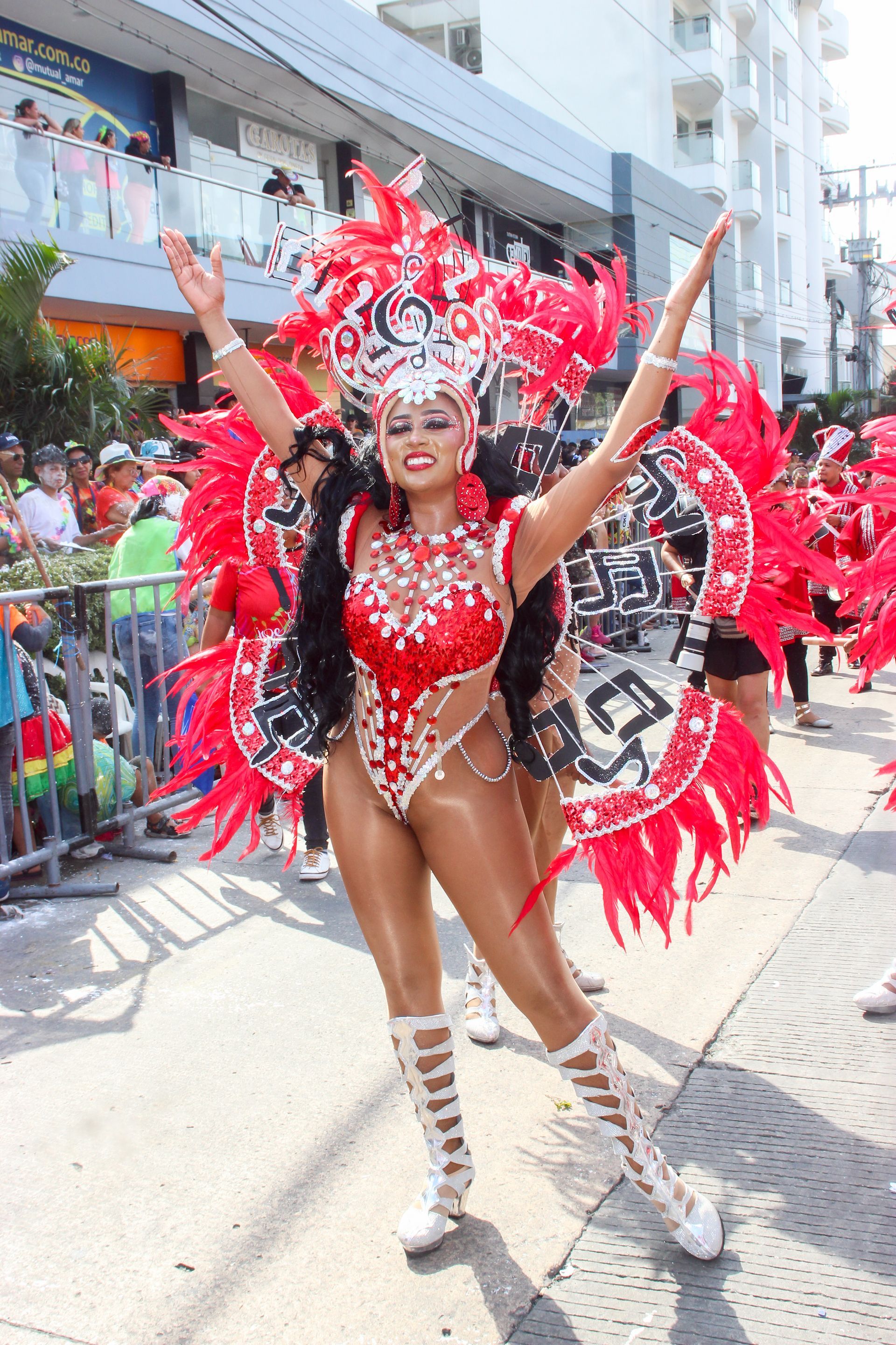 Una mujer con un disfraz de carnaval está parada en una calle.