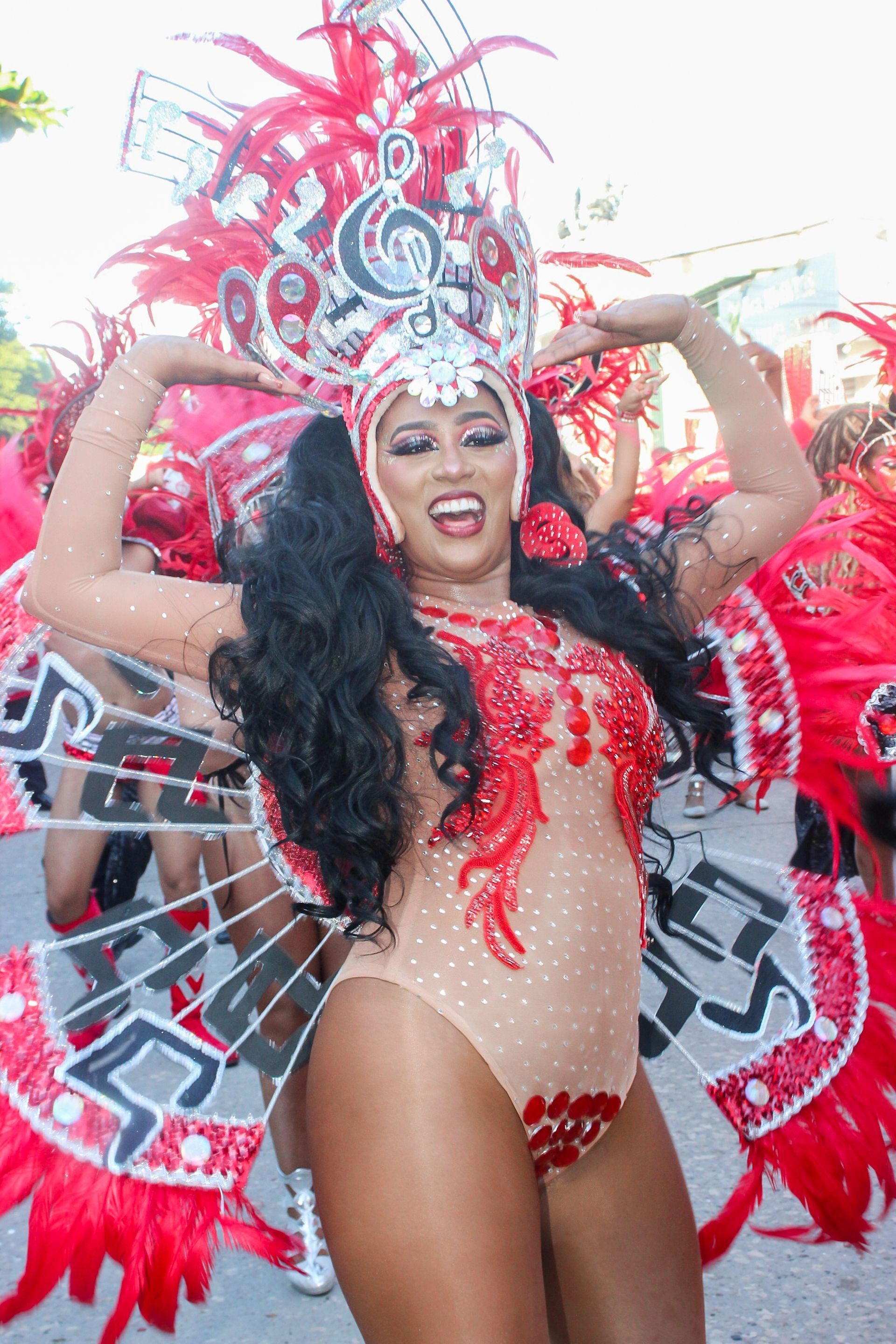 Una mujer con un disfraz de carnaval está bailando en un desfile.