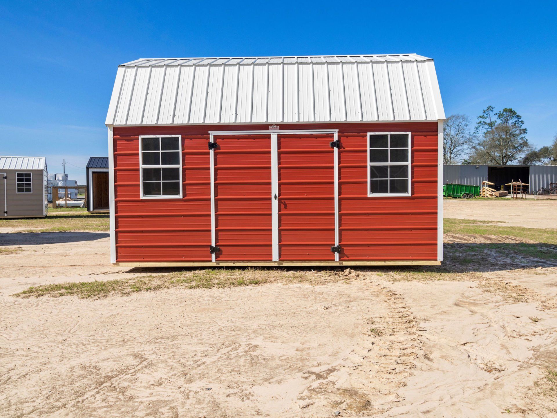 Metal Side Lofted Barn style building with double transom doors and decorative hinges