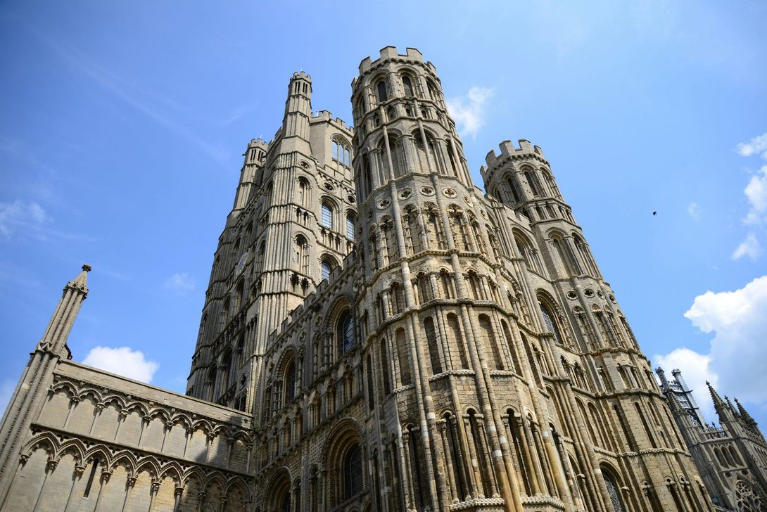 Gothic cathedral exterior against a bright blue sky; ornate architecture and towers rise.