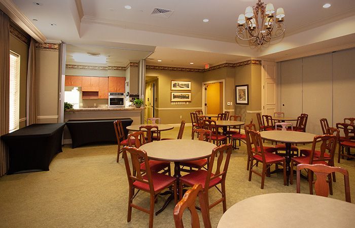 A large room with tables and chairs and a chandelier