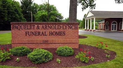 A brick sign for paquelet & arnold lynch funeral homes