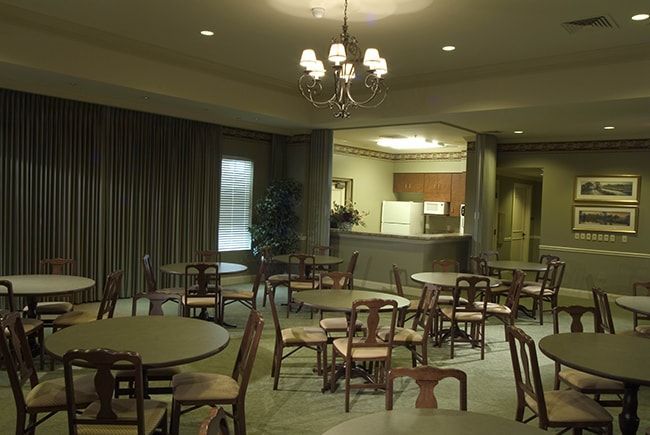 A kitchen with tables and chairs and a bulletin board