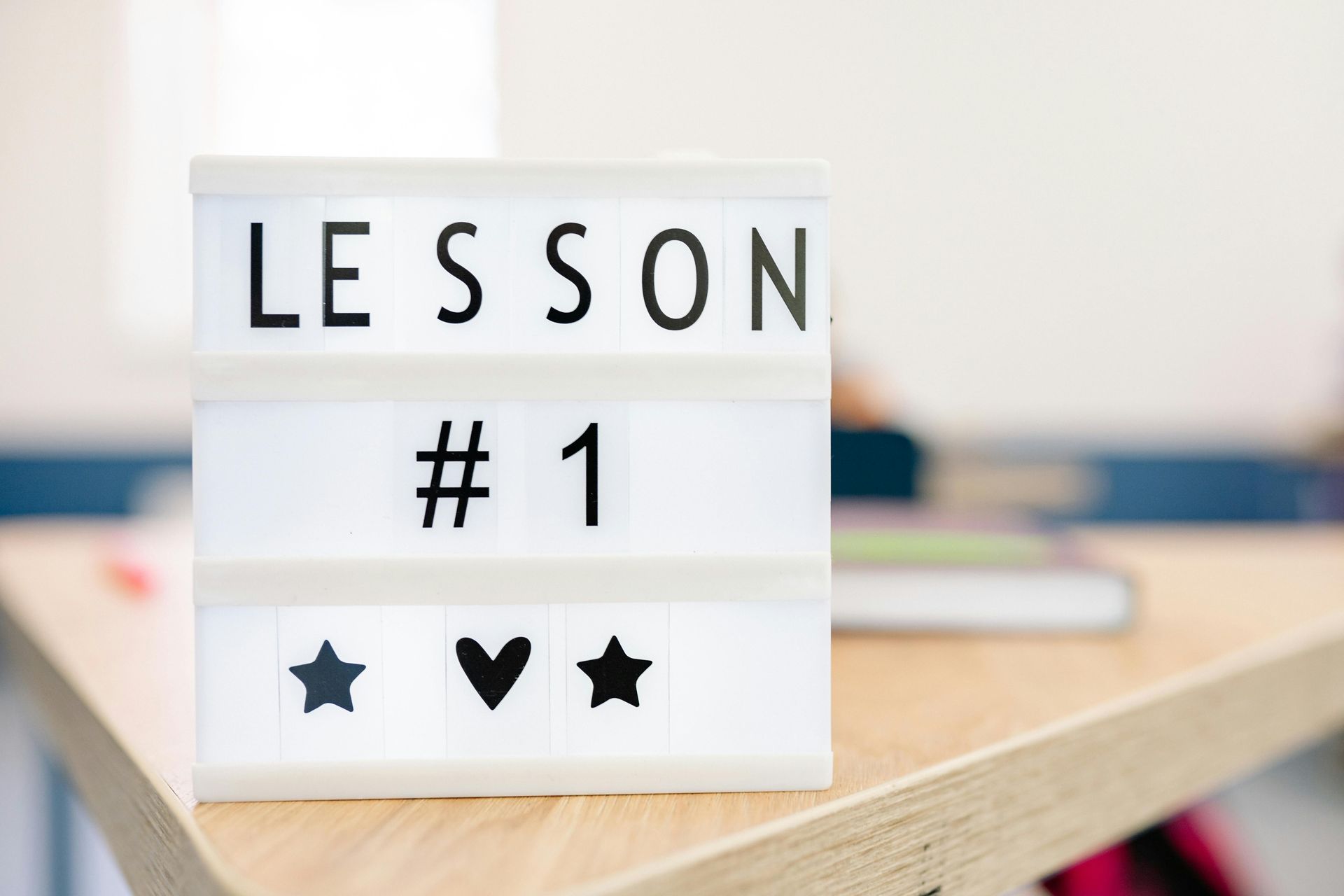 A sign that says lesson # 1 is on a wooden table.