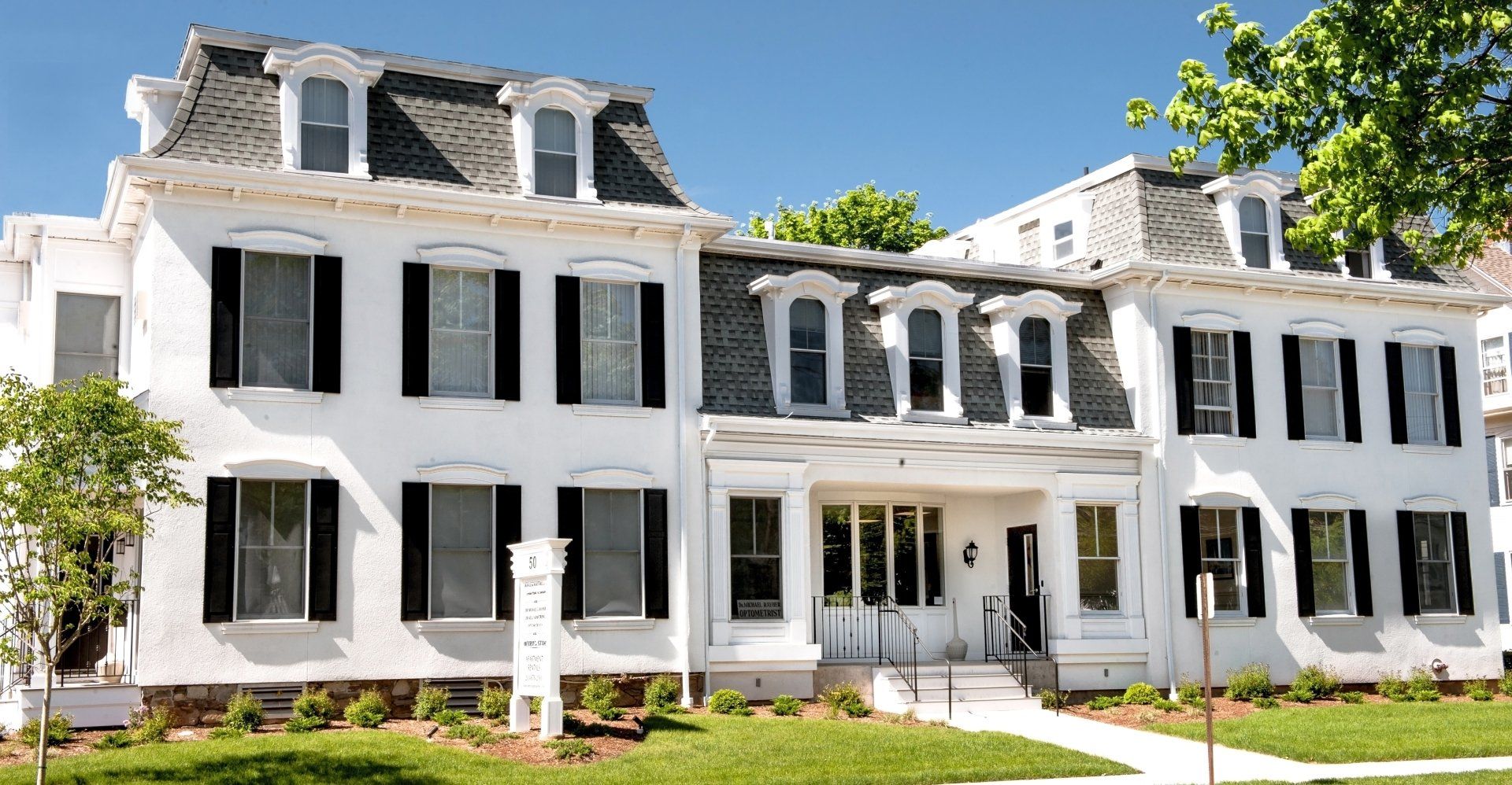 A large white building with black shutters on the windows