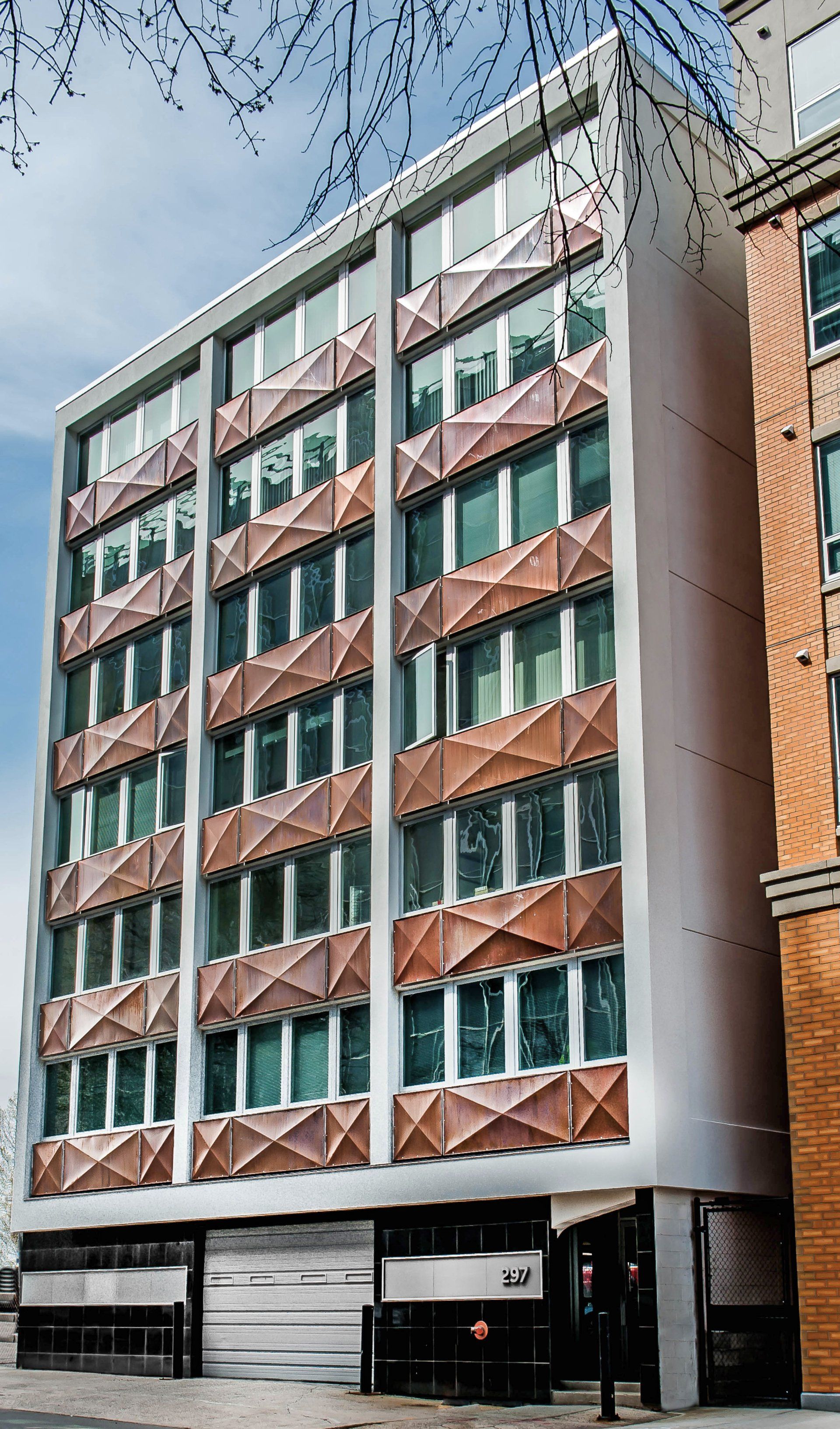 A large building with a lot of windows and a garage in front of it.