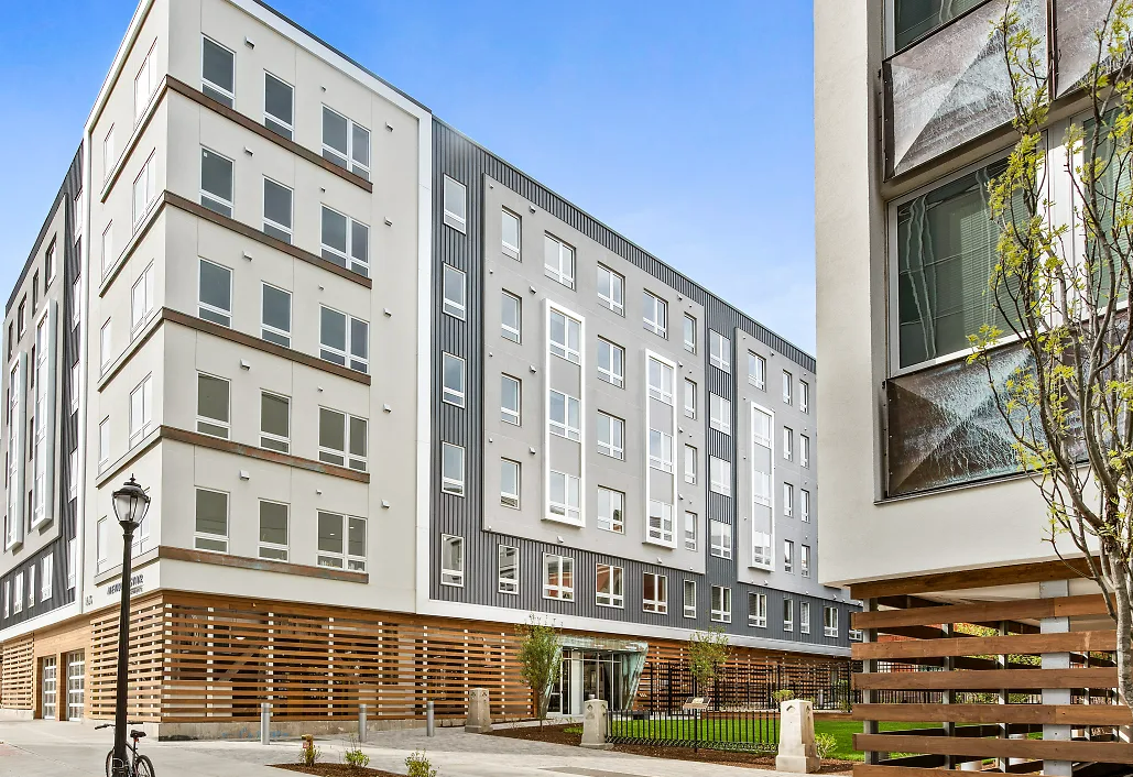 A large building with a lot of windows and a wooden fence in front of it.