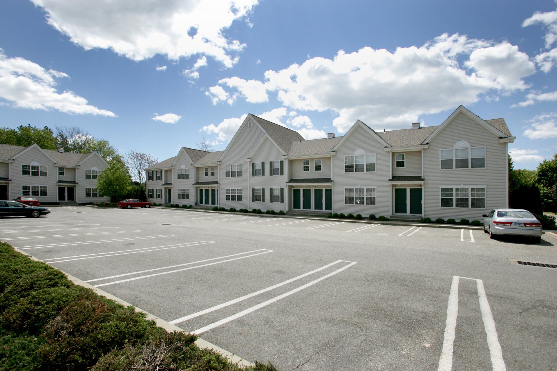 A large white building with a parking lot in front of it