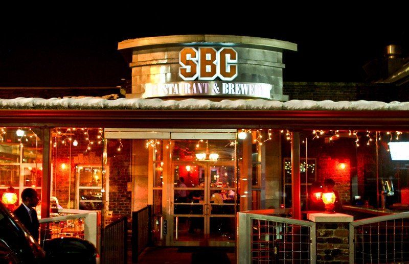 A restaurant called sbc is lit up at night