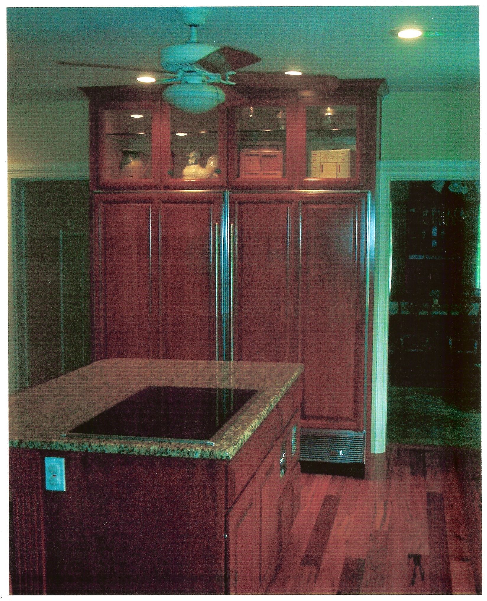 A kitchen with a stove top oven and a ceiling fan