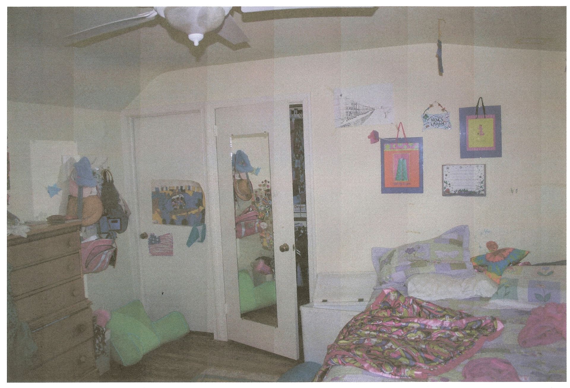 A bedroom with a bed and a ceiling fan