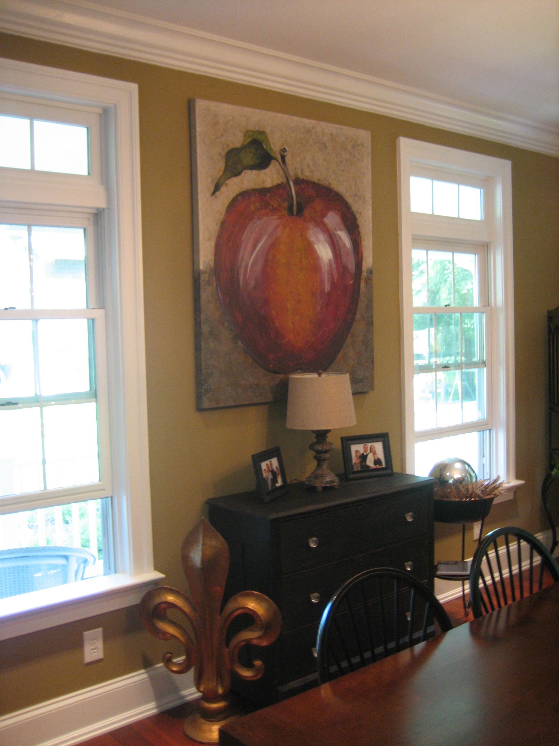 A dining room with a painting of an apple on the wall