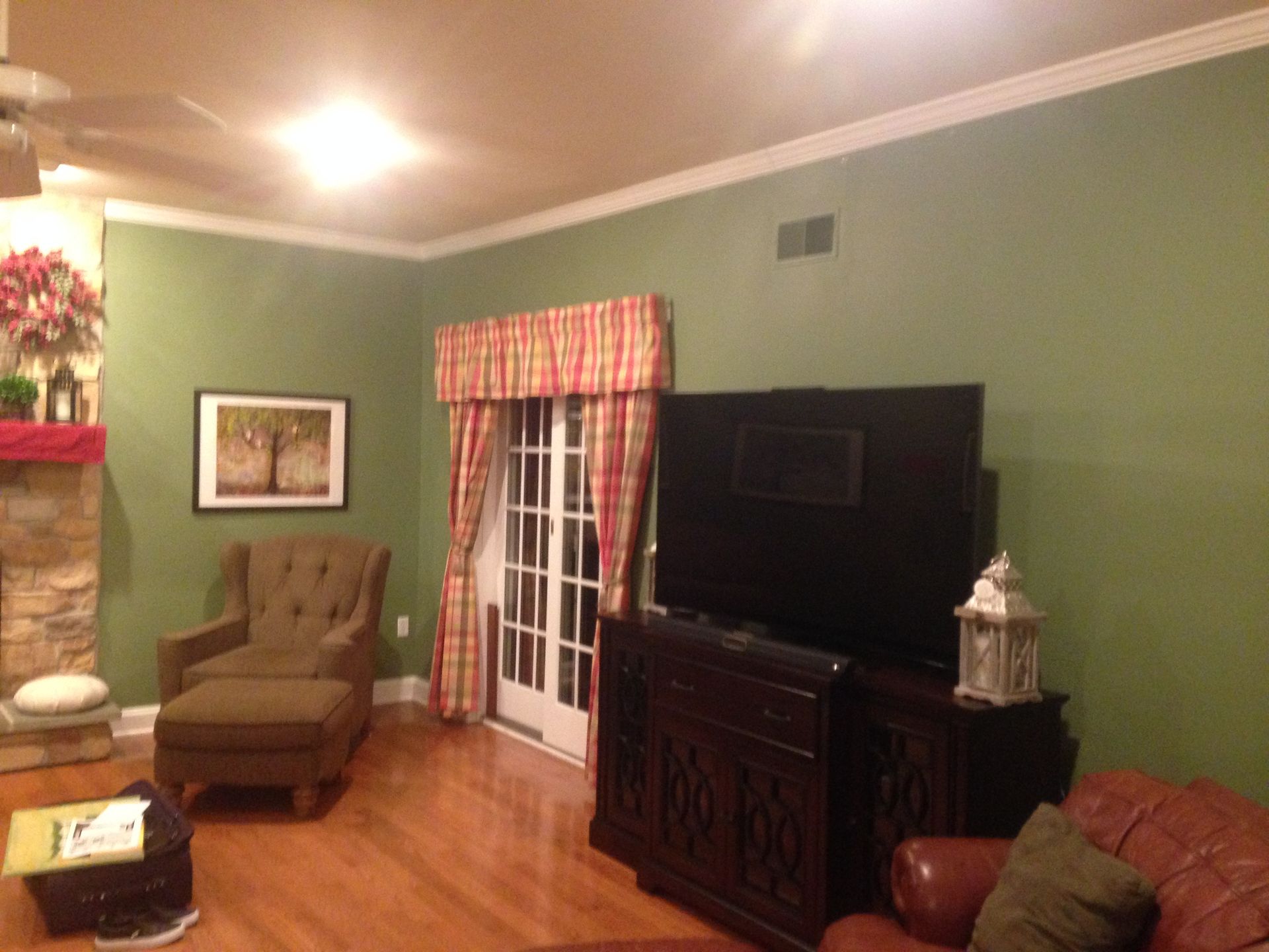 A living room with green walls and a flat screen tv