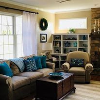 A living room with a couch , chair , coffee table and fireplace.