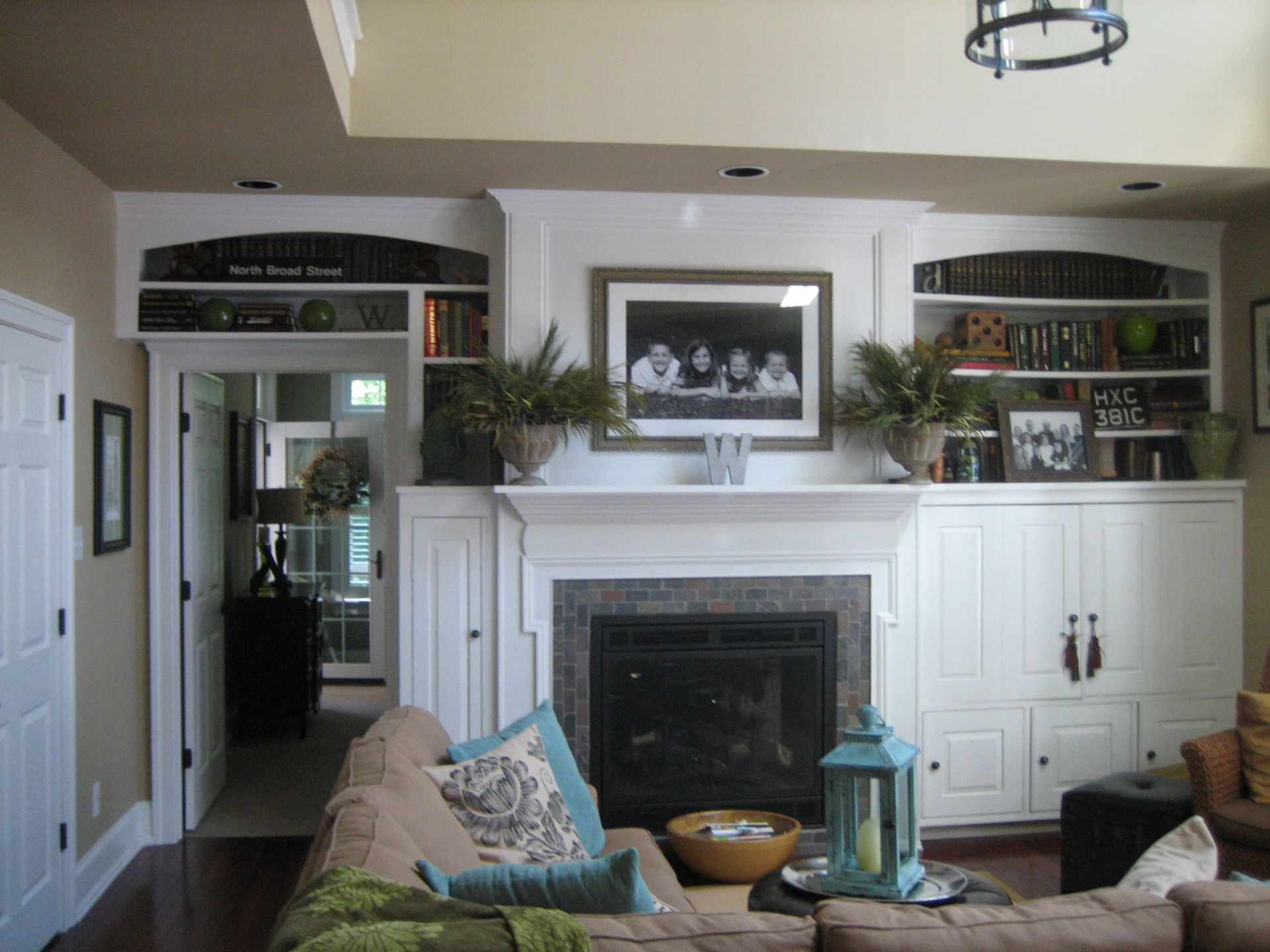 A living room with a fireplace and a picture above it