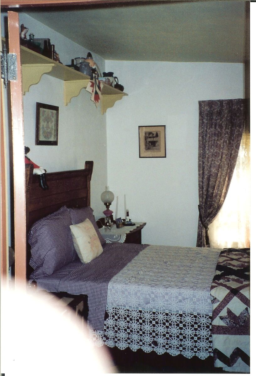 A bedroom with a bed and a picture on the wall