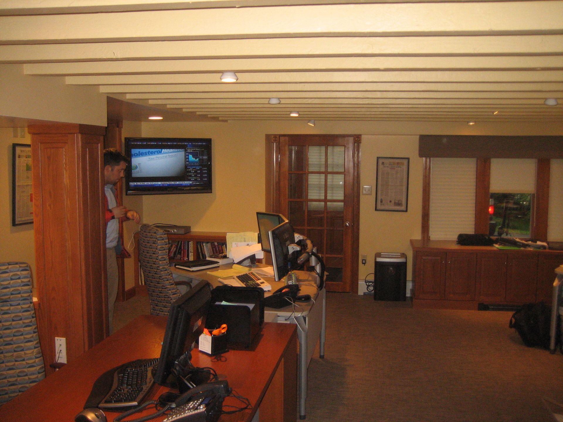 A man stands in a room with a tv on the wall