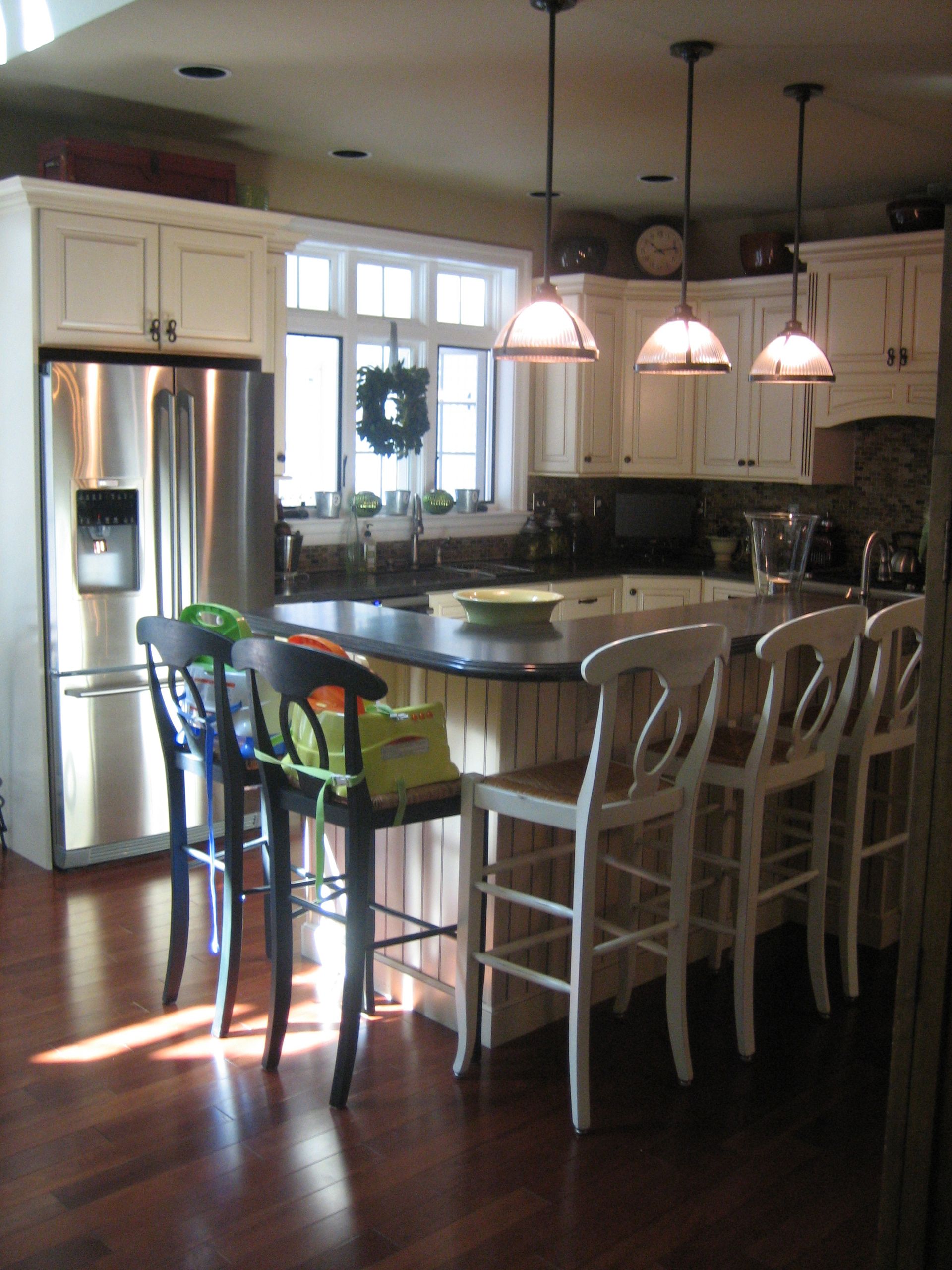 A kitchen with white cabinets and a stainless steel refrigerator