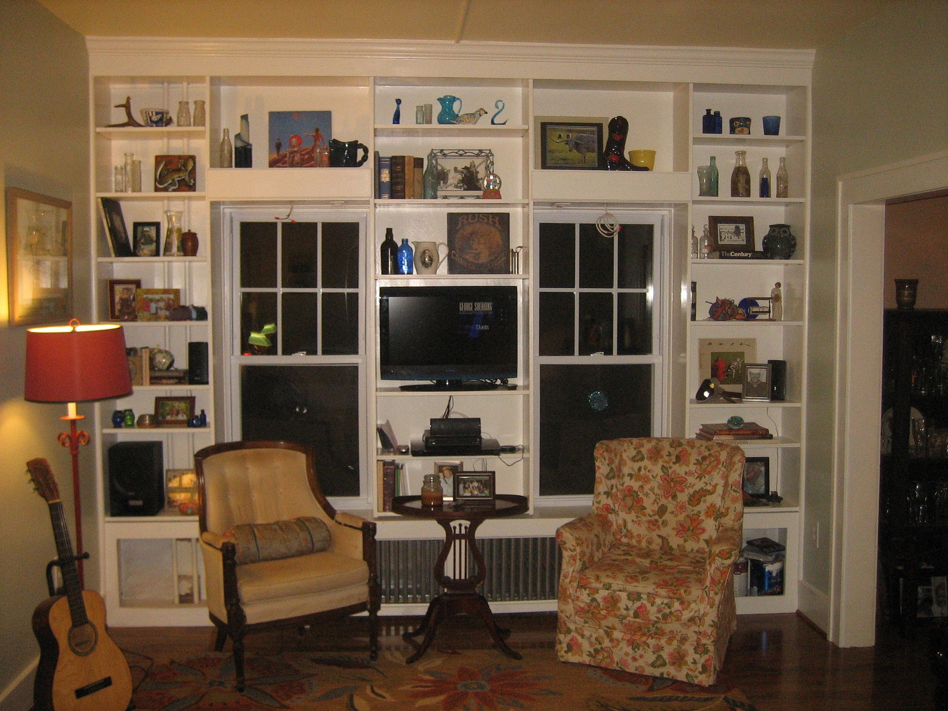 A living room filled with furniture including a chair and a guitar
