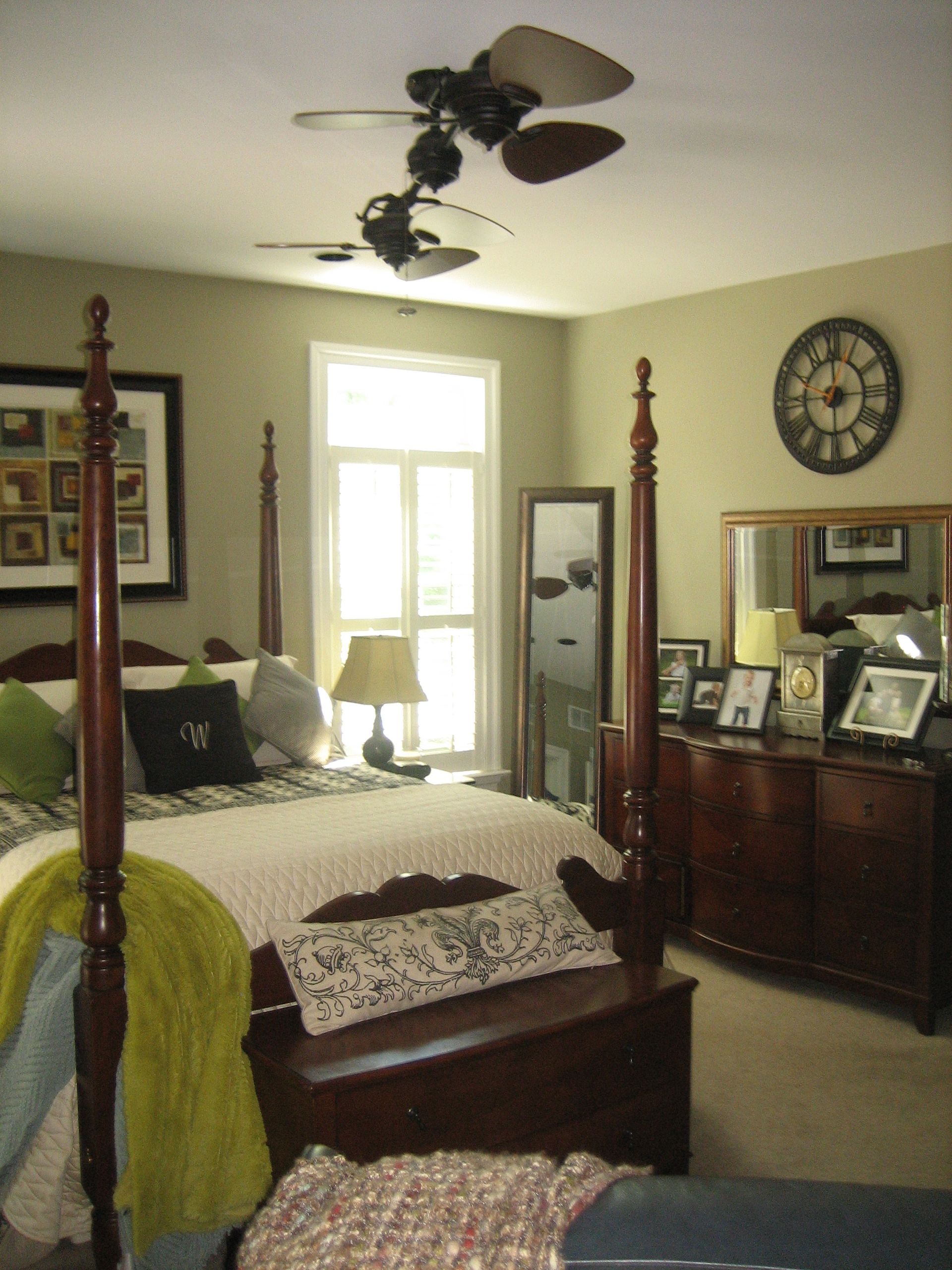 A bedroom with a four poster bed and a clock on the wall