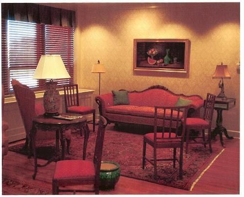 A living room with a red couch and chairs