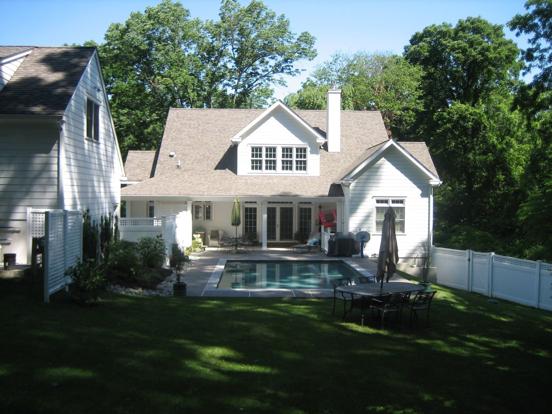 A large white house with a swimming pool in the backyard