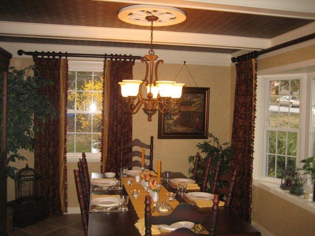 A dining room with a long table and chairs and a chandelier