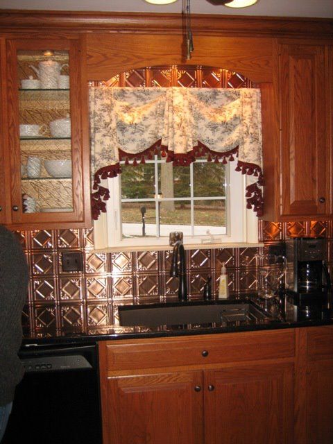 A kitchen with wooden cabinets a sink and a window