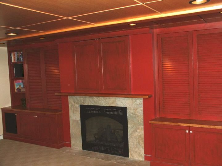 A living room with red cabinets and a fireplace