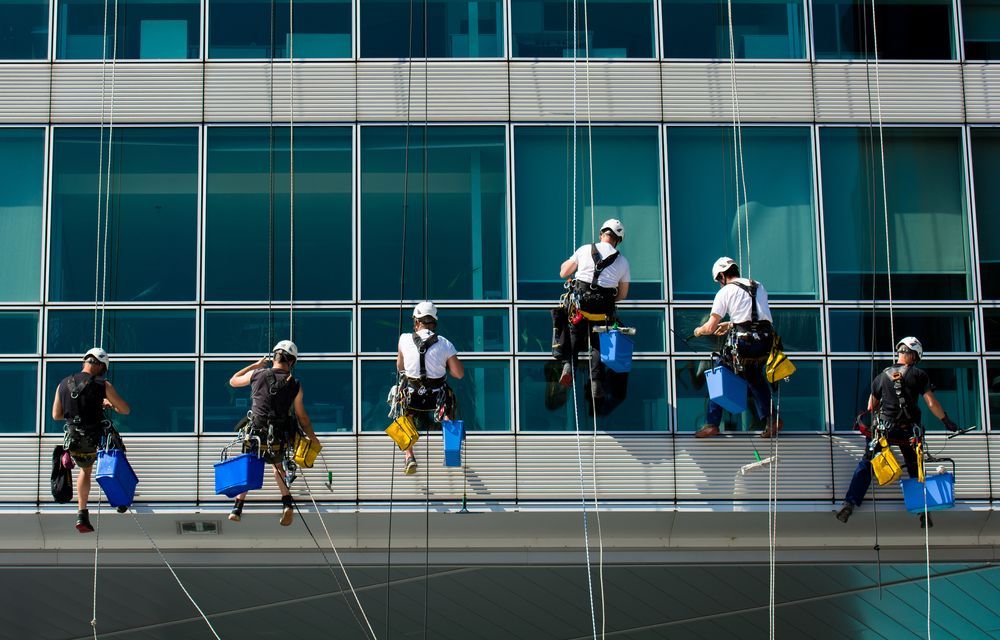 A Group of Men Are Cleaning the Windows of a Building — Reach 'N' Clean in Lismore, NSW