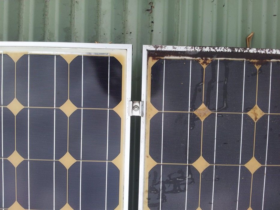 Two Solar Panels Are Sitting Next to Each Other on a Green Wall — Reach 'N' Clean in Byron Bay, NSW