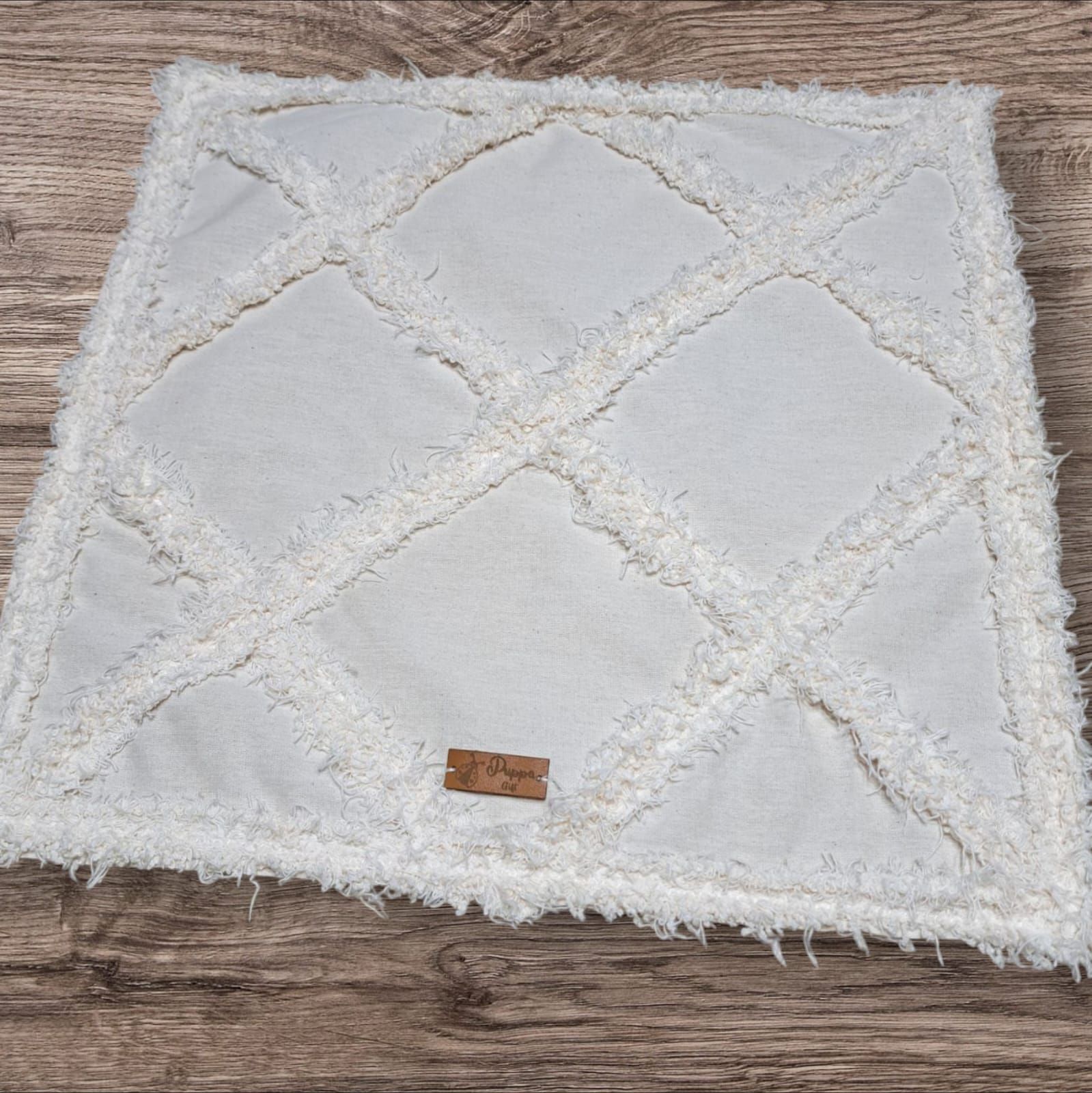 Una alfombra blanca está sobre una mesa de madera.
