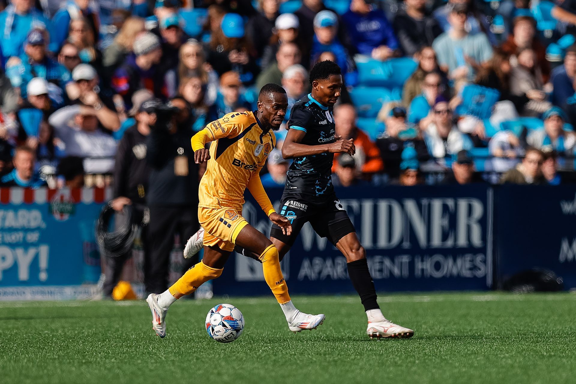 Aerial view of Colorado Springs, Colorado, featuring urban buildings with a large mountain range in the background.
