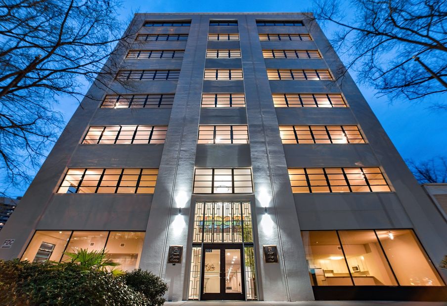 Modern, multi-story building with many lit windows; night setting.