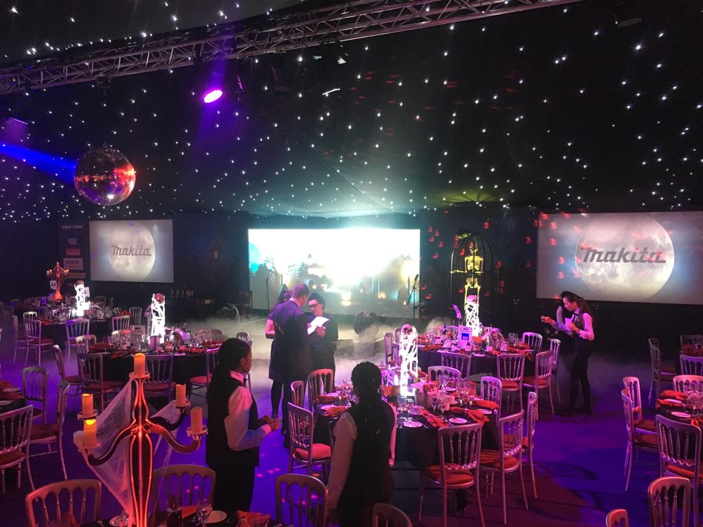 A large room filled with tables and chairs and a disco ball.