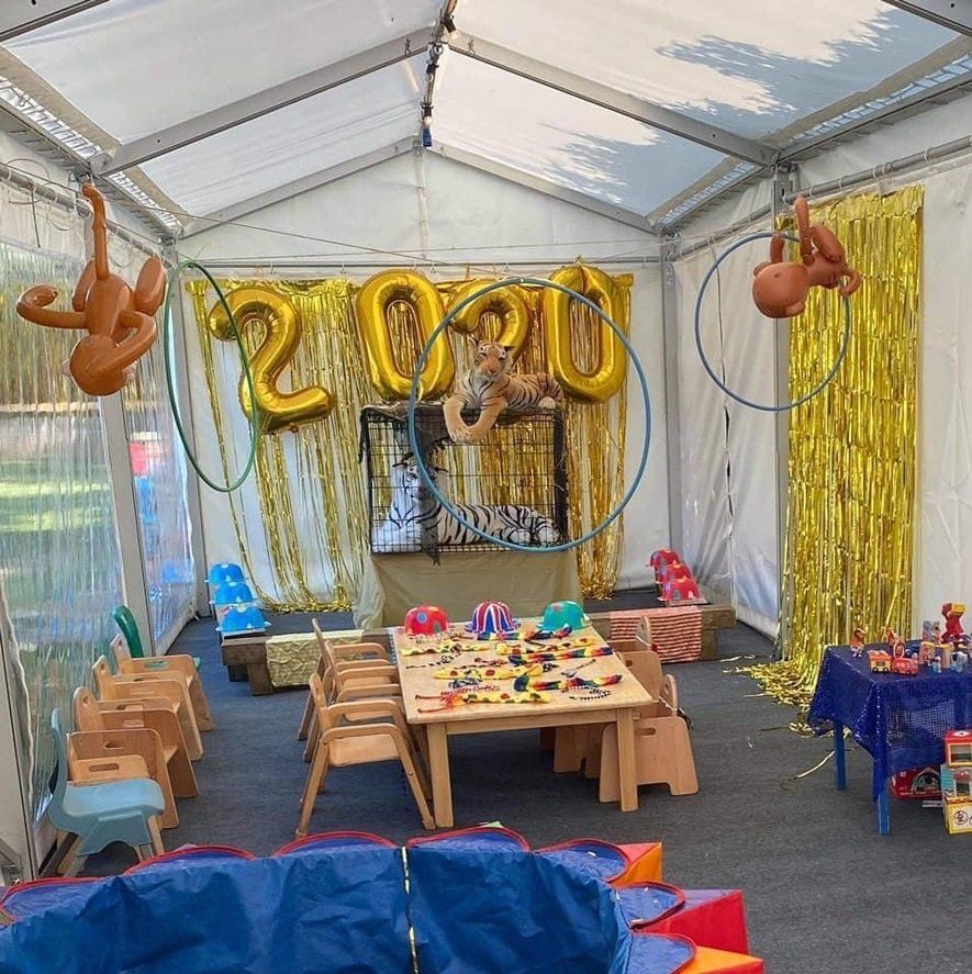 A room with tables and chairs and balloons that say 2020
