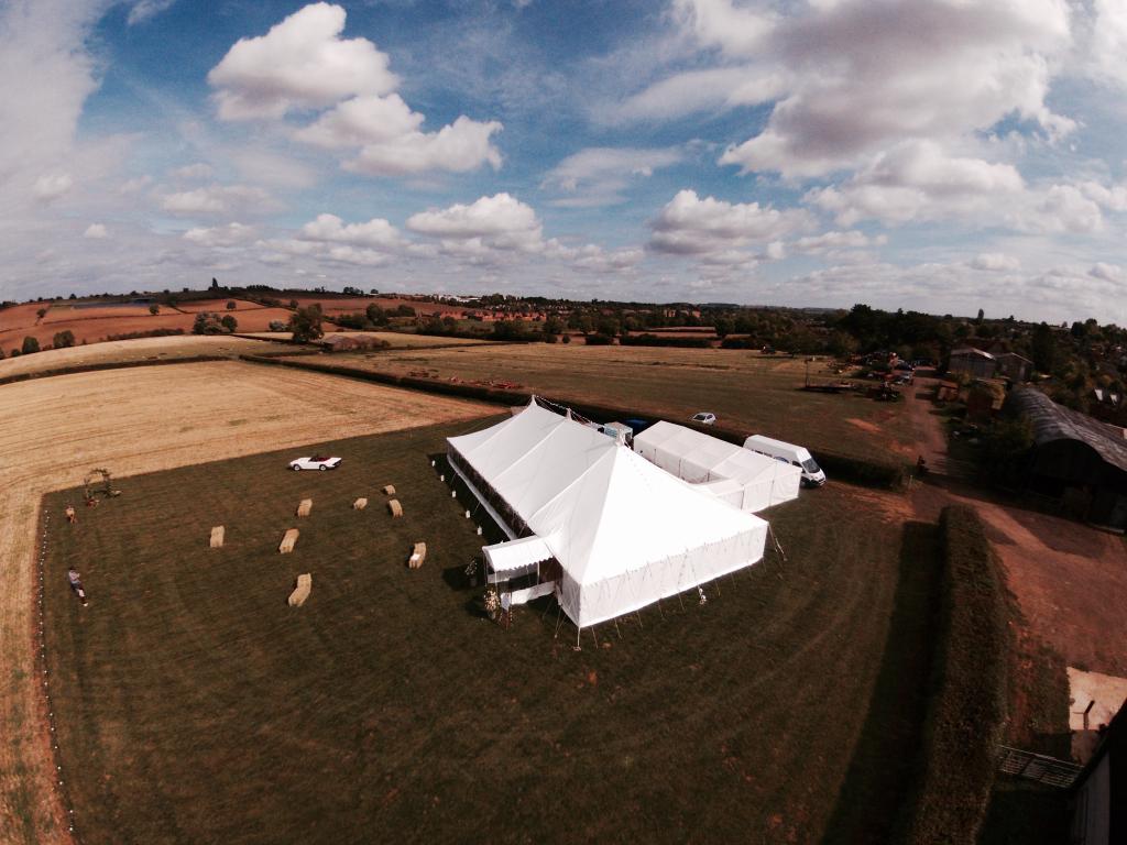 An aerial view of a large white tent in a field