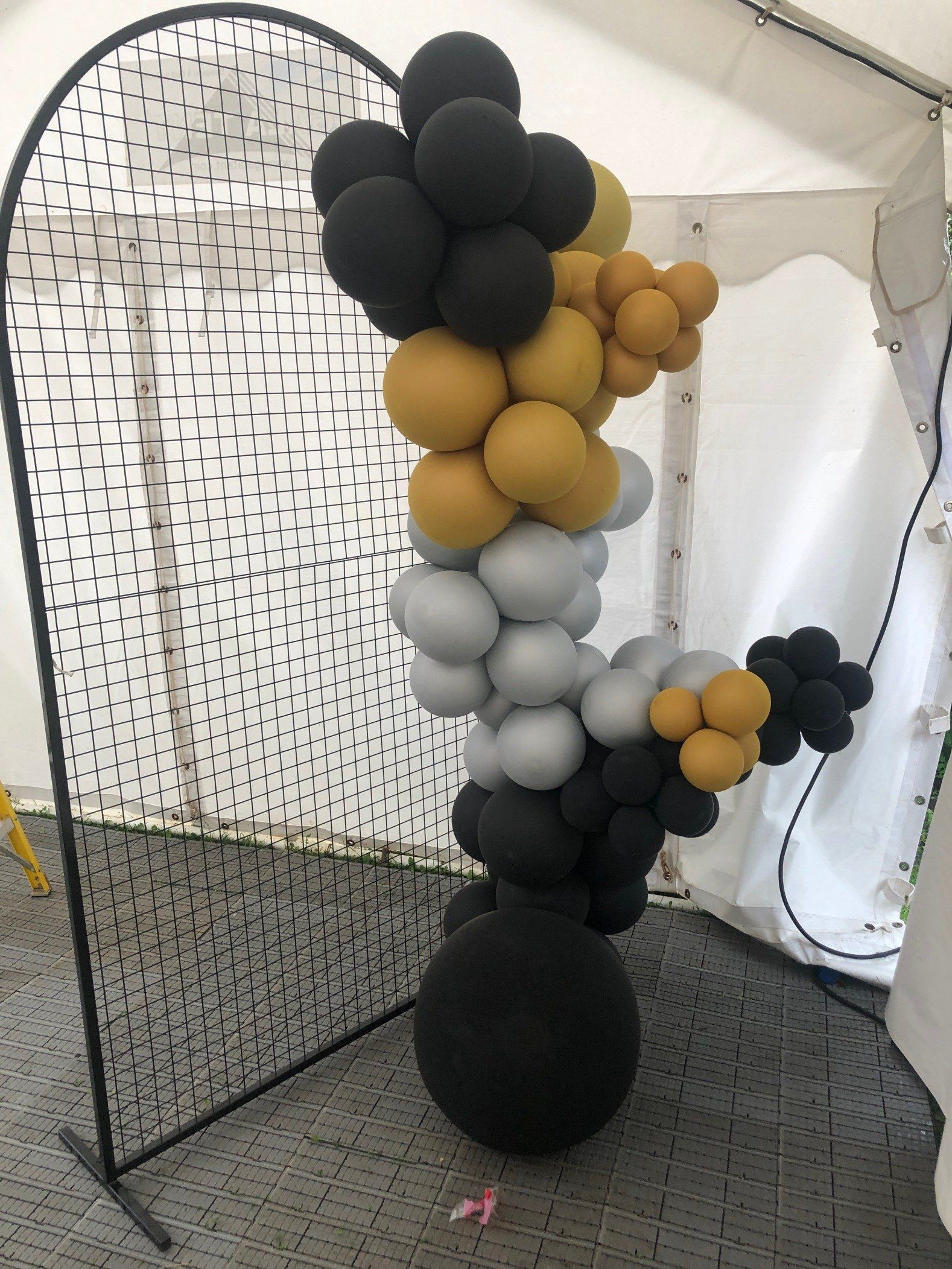 A bunch of balloons are sitting on a table in front of a tent.