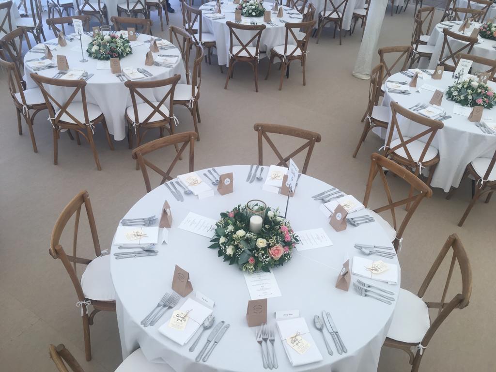 A large room with tables and chairs set up for a wedding reception.