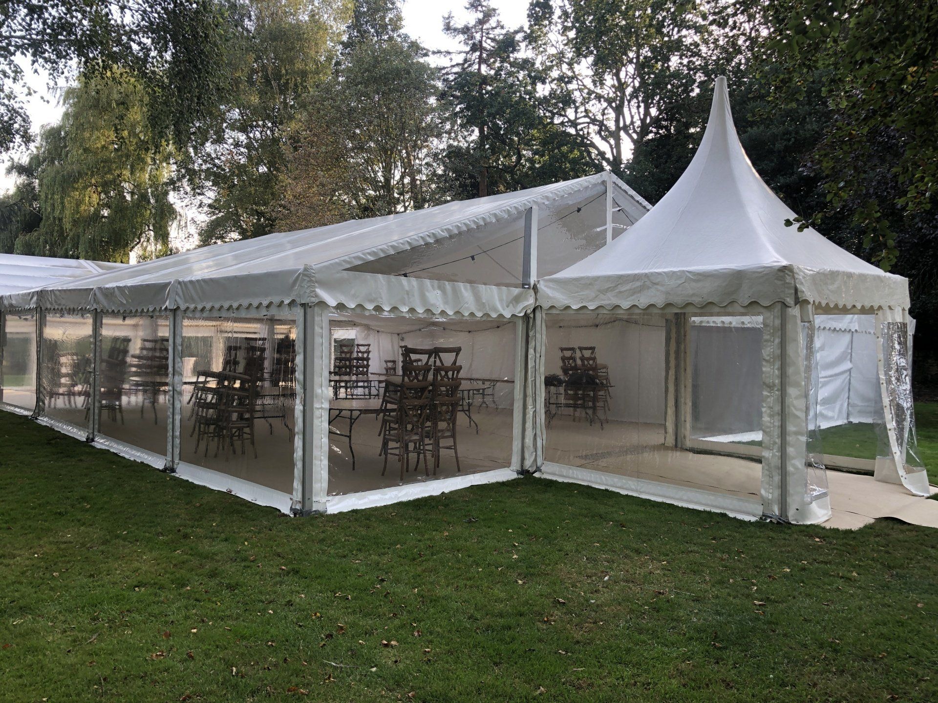 A large white tent is sitting on top of a lush green field.