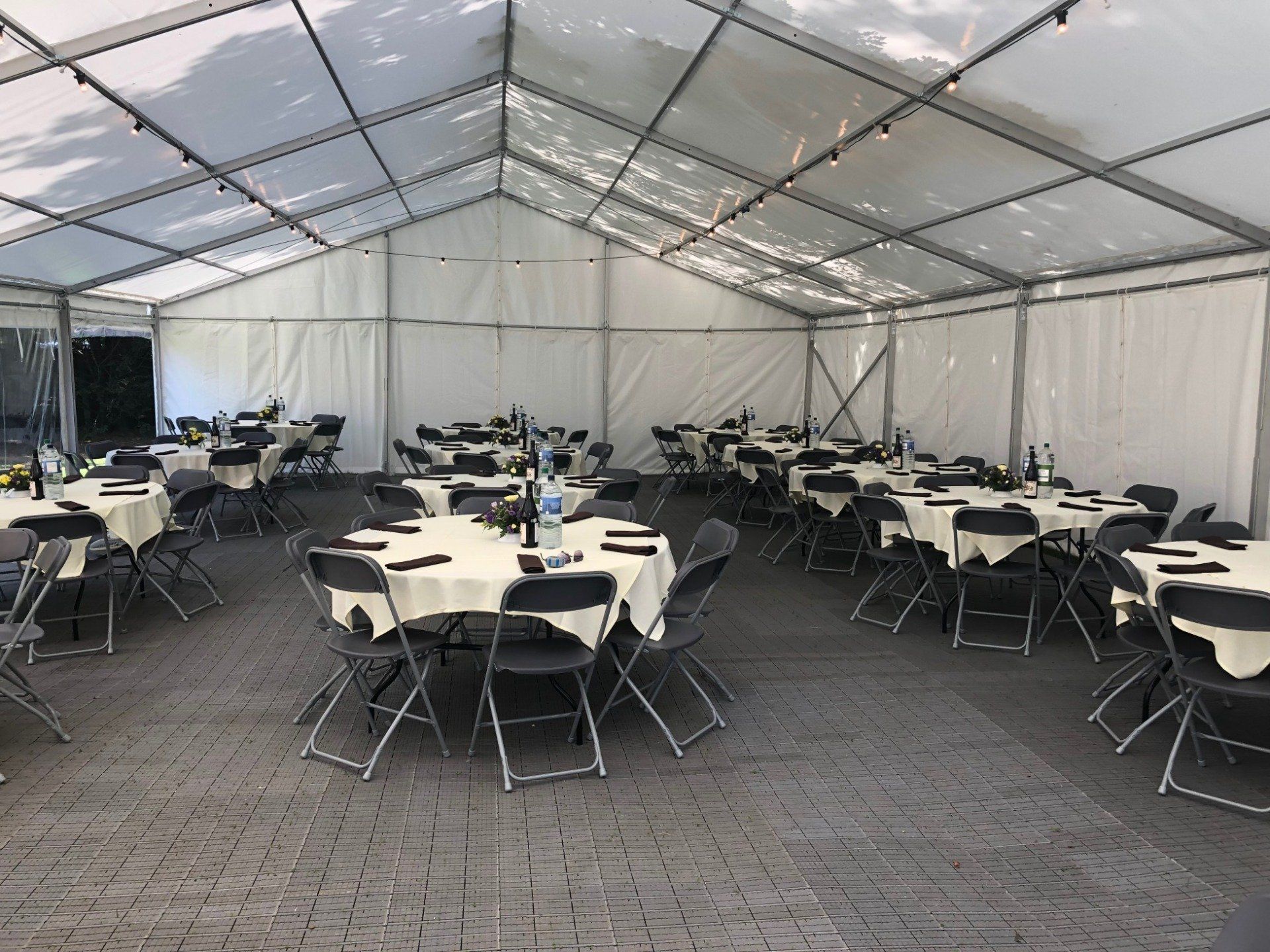 A large tent with tables and chairs set up for a party.
