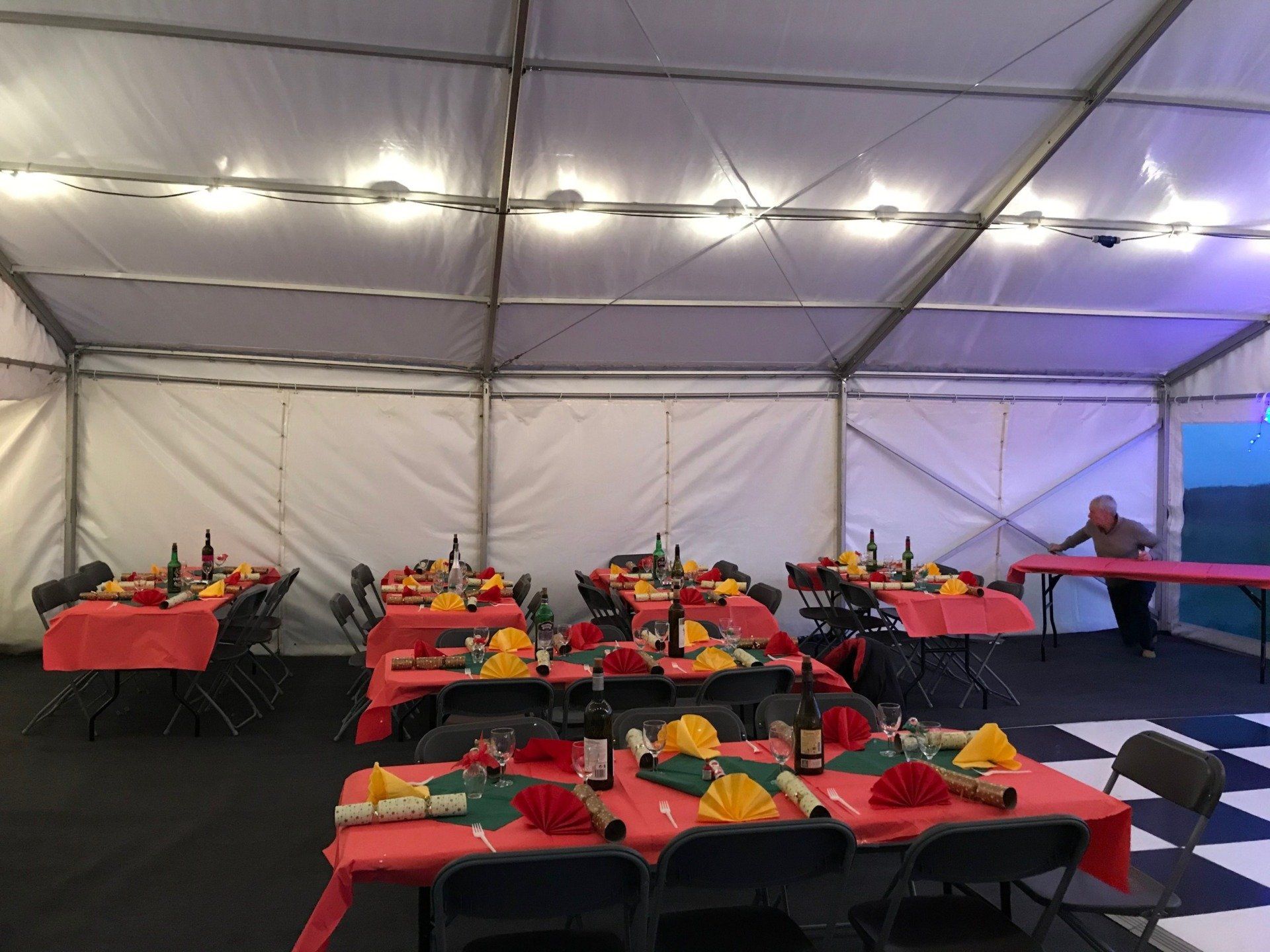 A large tent with tables and chairs set up for a party.