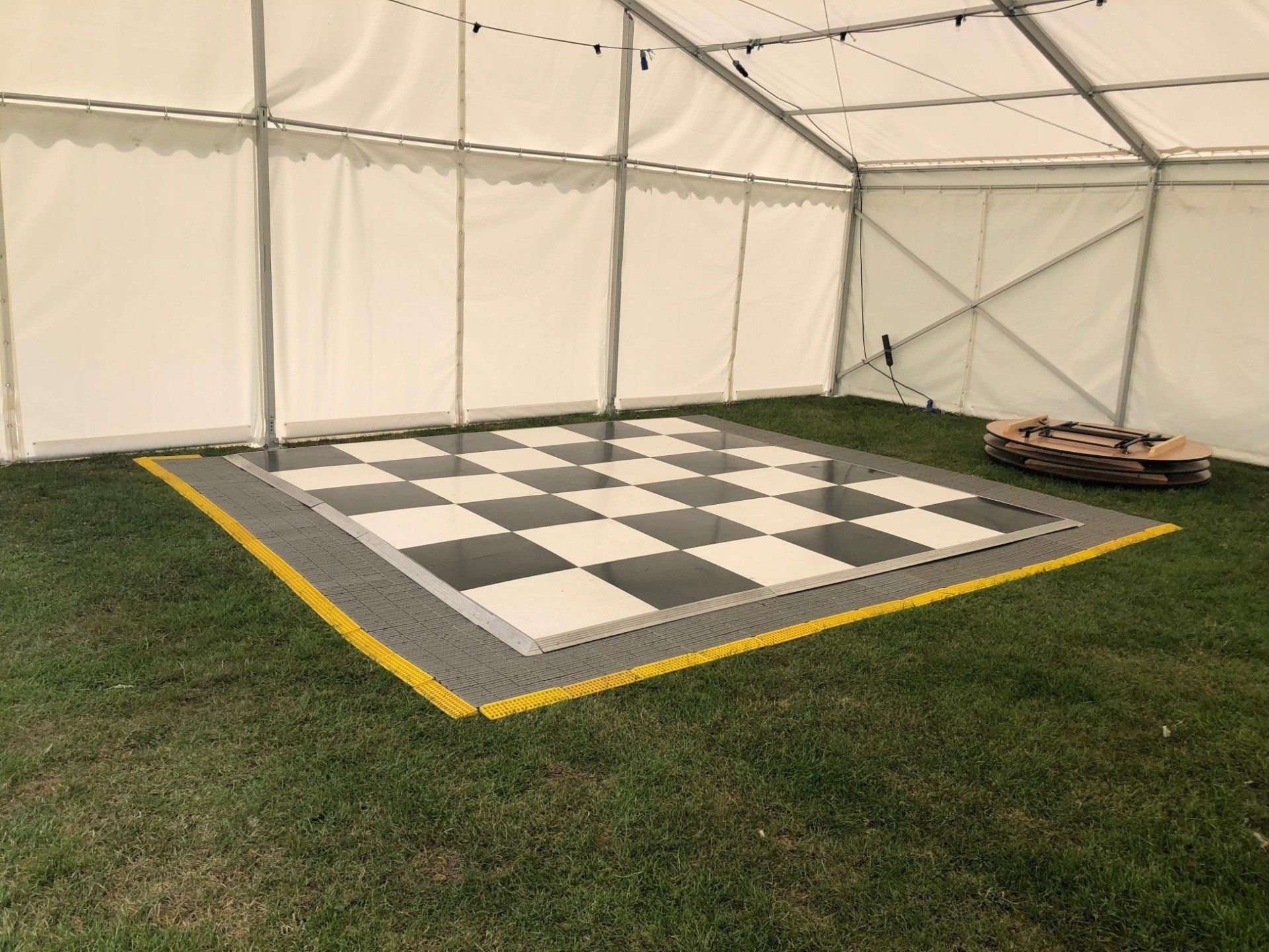A black and white checkered dance floor in a tent.