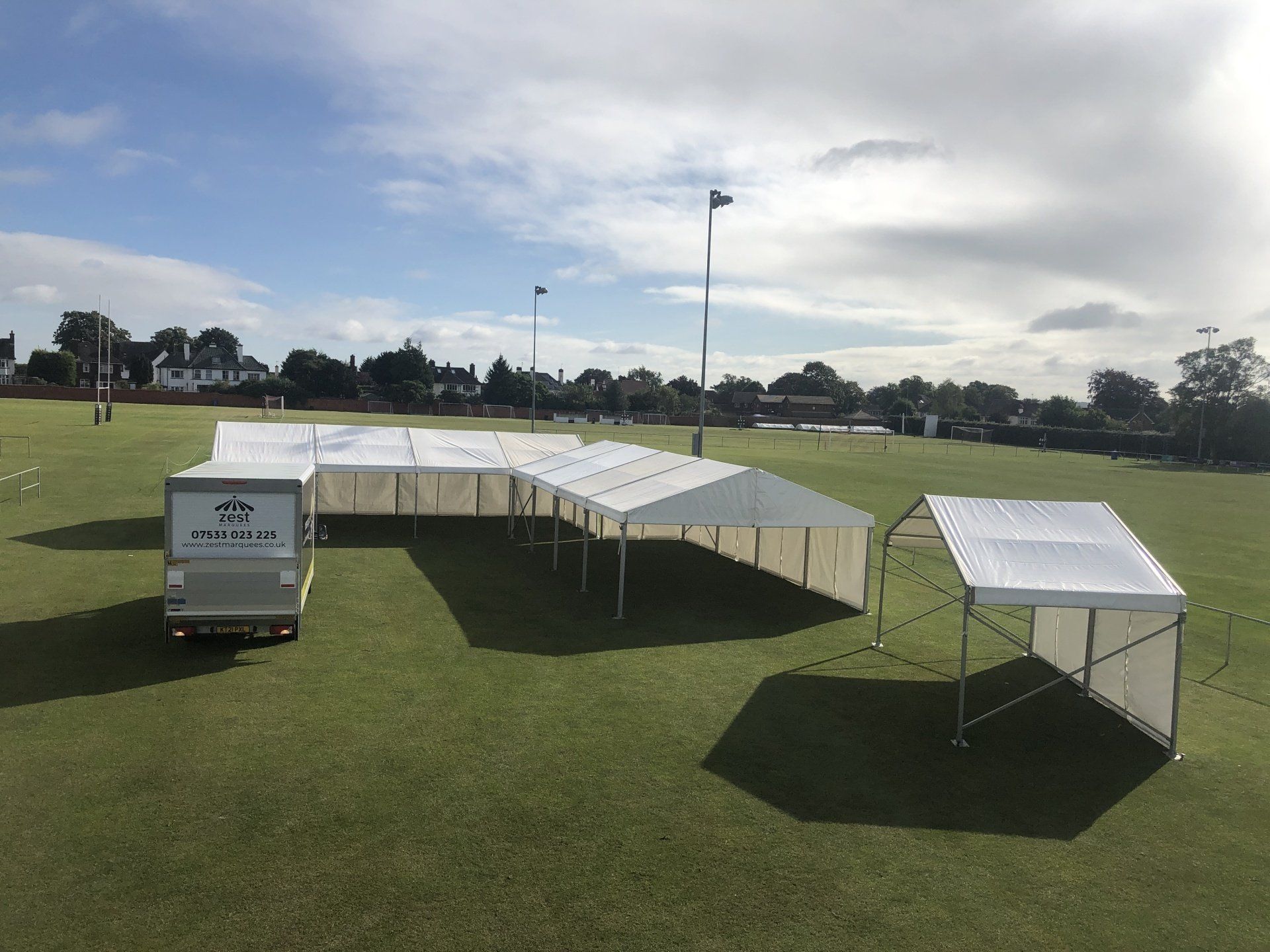 A large white tent is sitting on top of a lush green field.