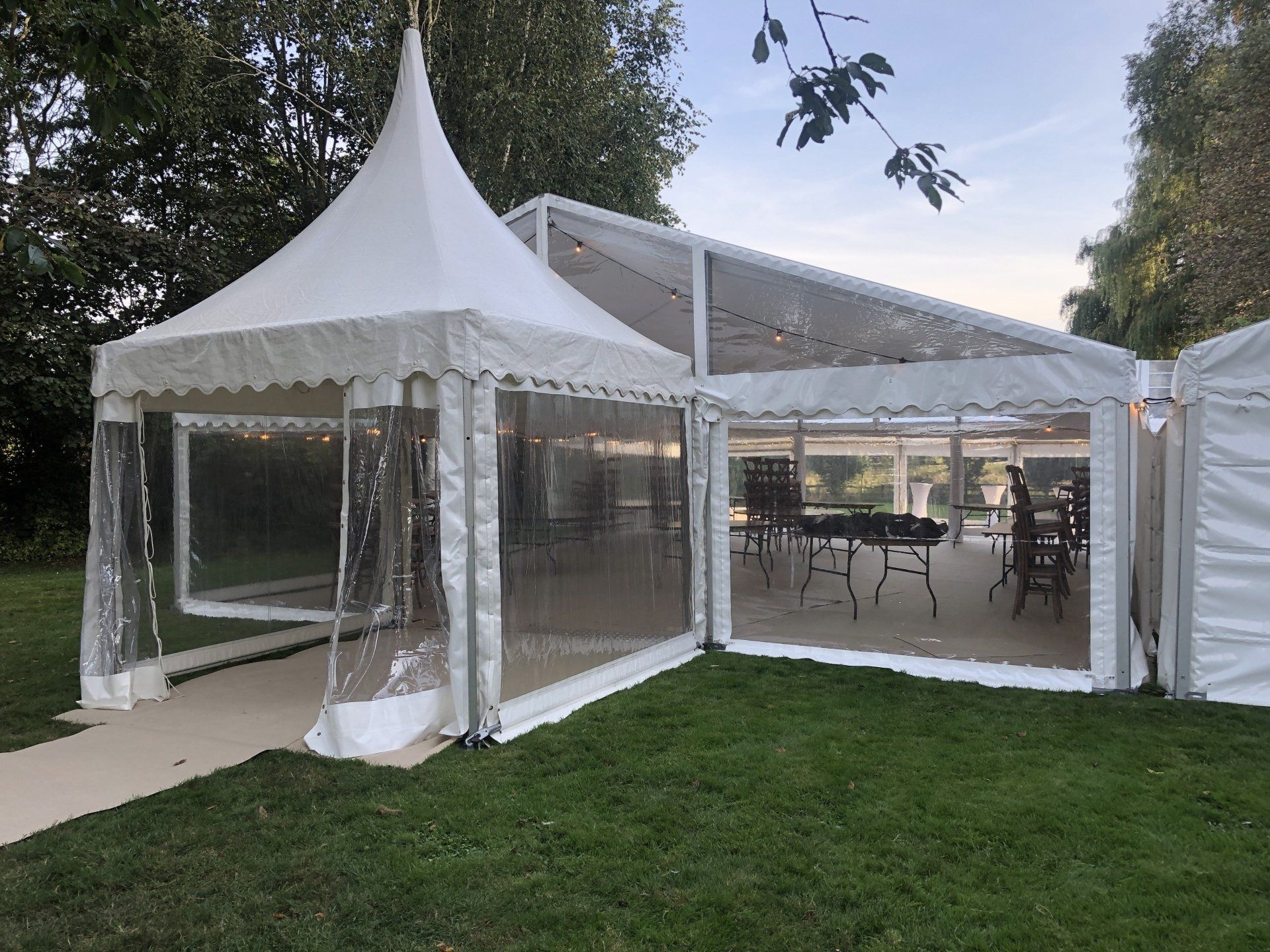 A large white tent is sitting on top of a lush green field.