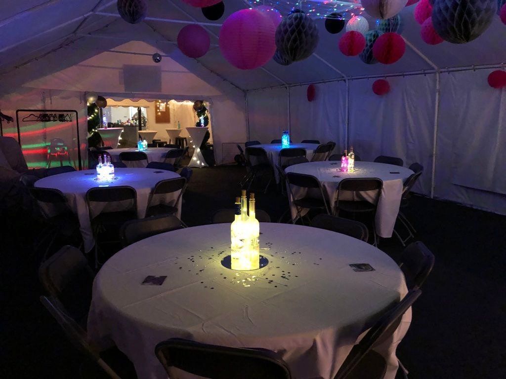 A tent with tables and chairs set up for a party