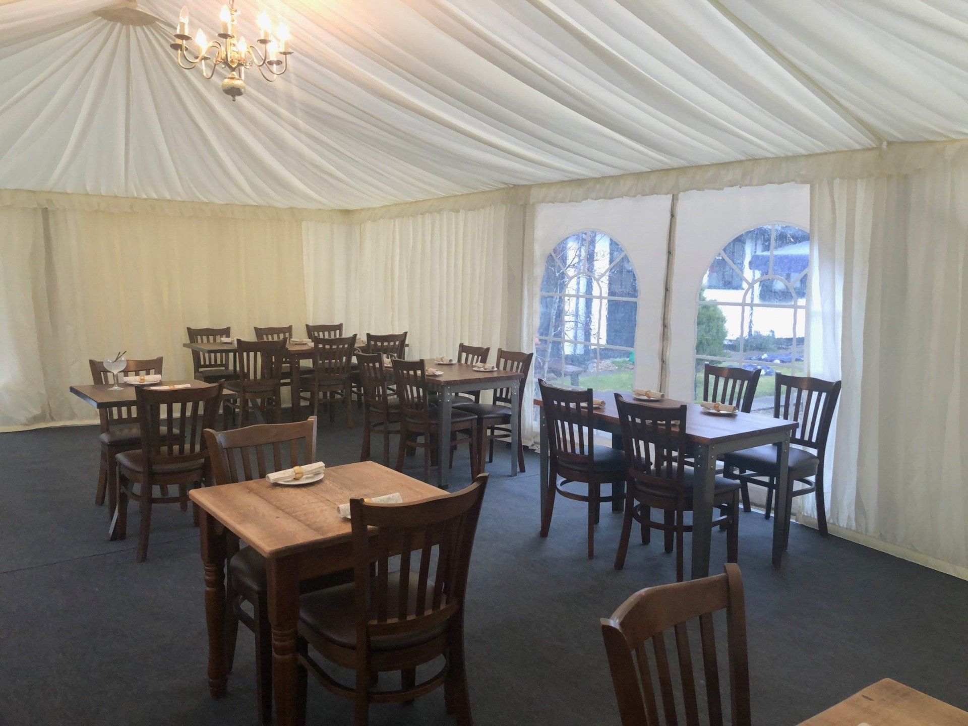 A restaurant with tables and chairs under a tent