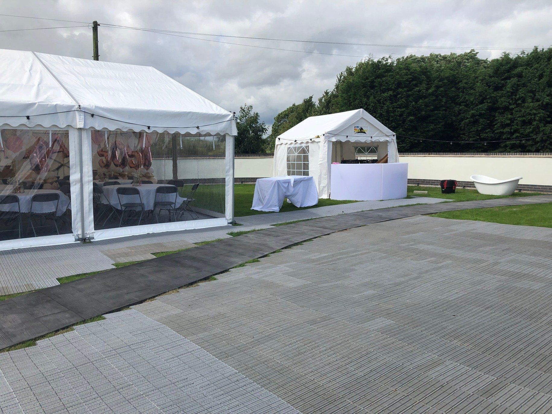 A white tent is sitting in the middle of a grassy field.