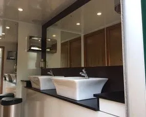 A bathroom with two sinks and a large mirror.