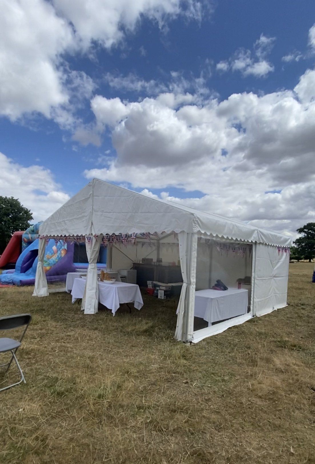 A large white tent is sitting in the middle of a field.